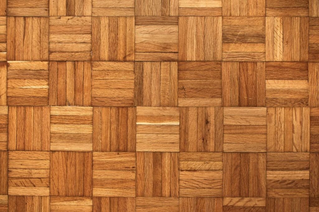 Gros plan sur un parquet en chêne disposé en damier, montrant le veinage naturel du bois dans des tons miel doré